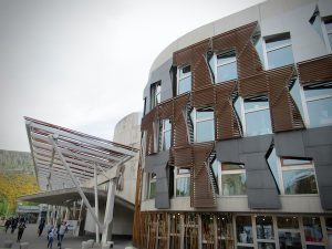 Catalan architect Enric Miralles died before the controversial structure could be built, leaving civil servants to interpret his design. This window controversial treatment was speculated to be a "7," a "sickle and hammer" and even a representation of a famous painting, "Skating Minister." It was later determined to simply be a curtain.